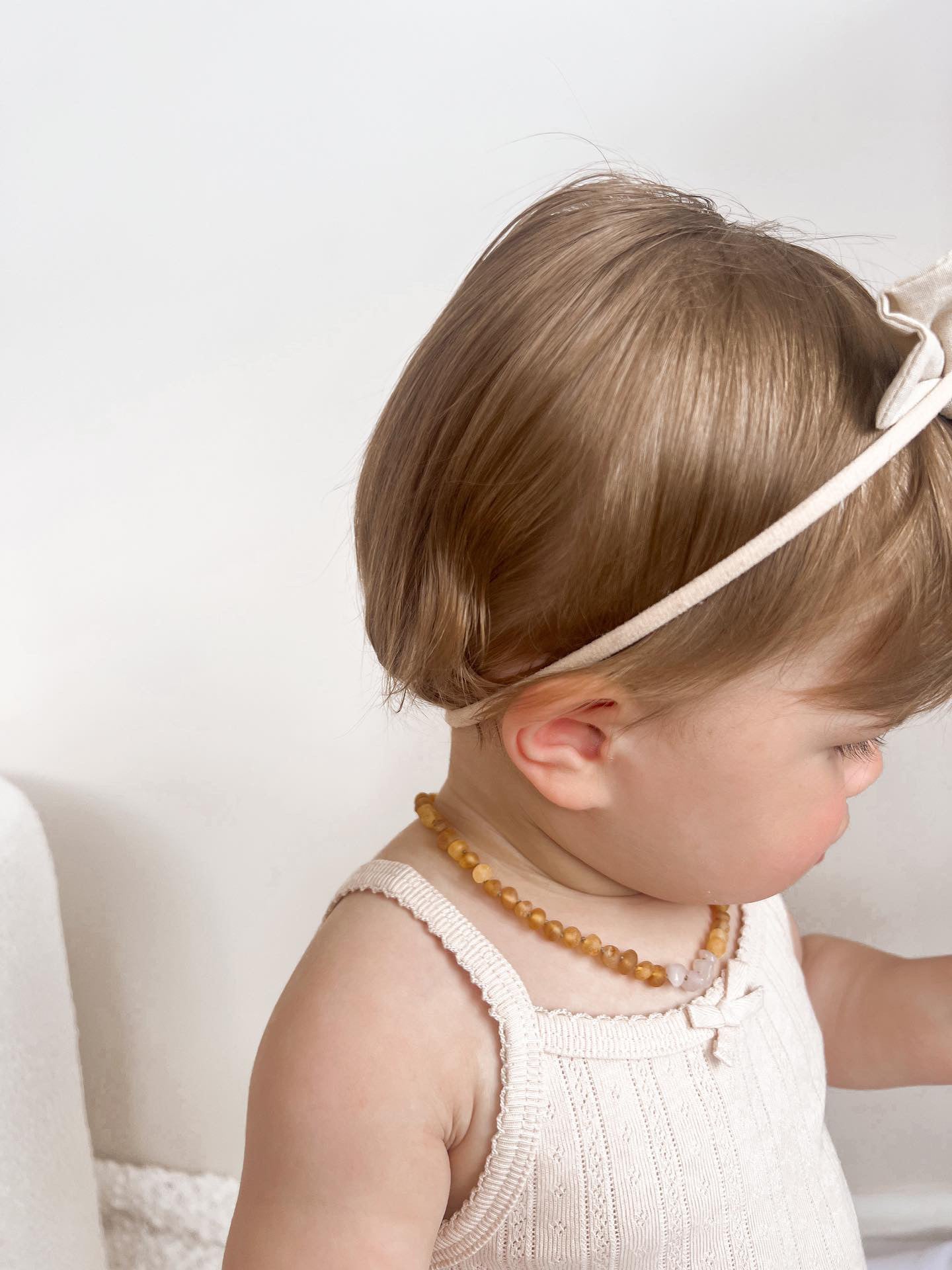 Toddler wearing Largo Amber teething necklace in Honey Amber.