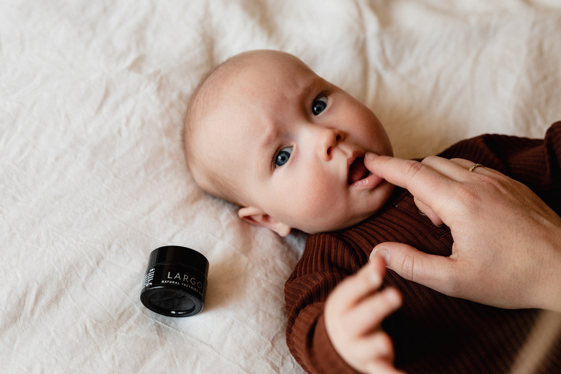 Mother applying Largo Natural Teething Gel to baby's gums