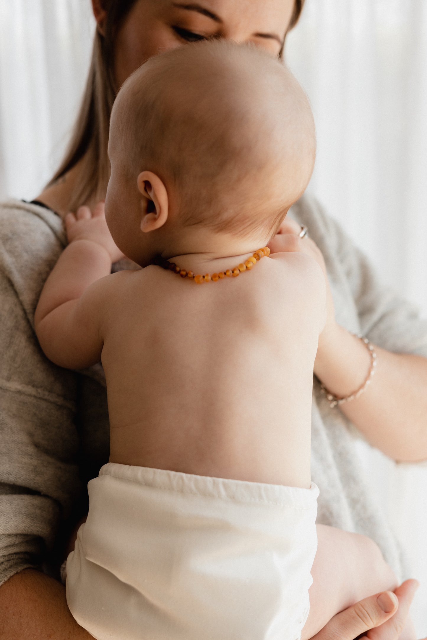 Mother and Child, baby wearing Largo Amber teething necklace in ombre- light to dark